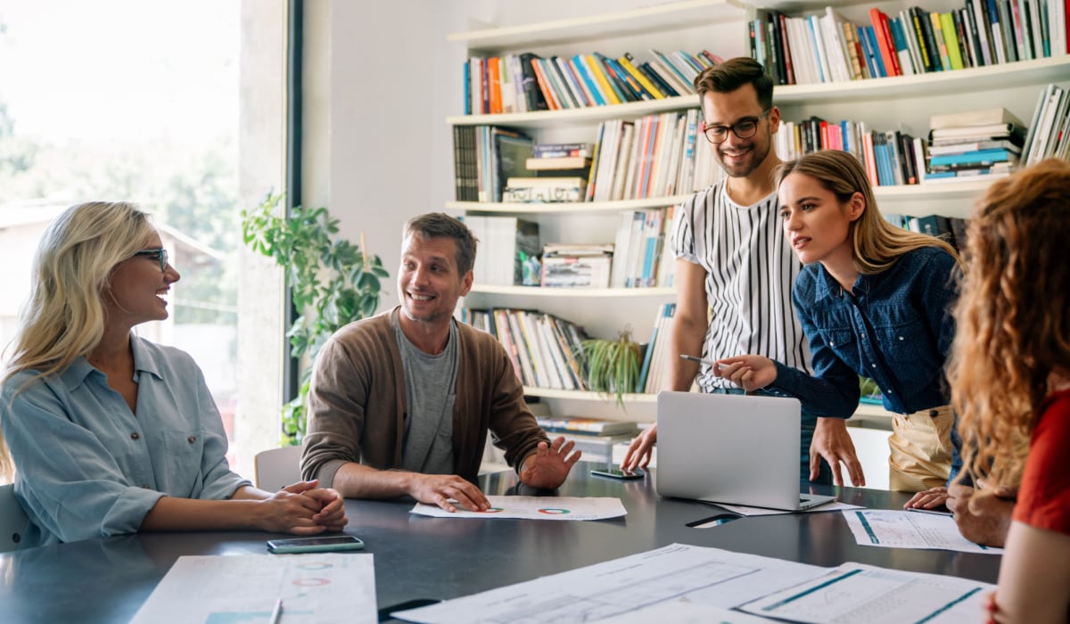 Hozio team collaborating in an office meeting, promoting coworking space management solutions.