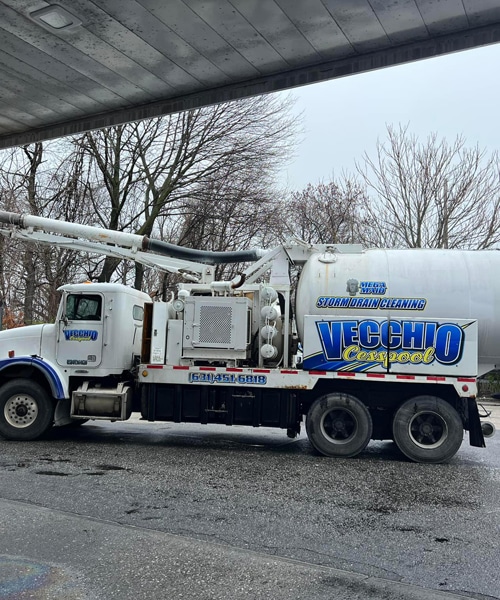Stormwater storm drain cleaning truck under bridge for professional drainage services.