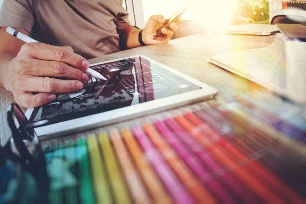 Creative digital artist working on a graphic design project with a stylus and tablet.