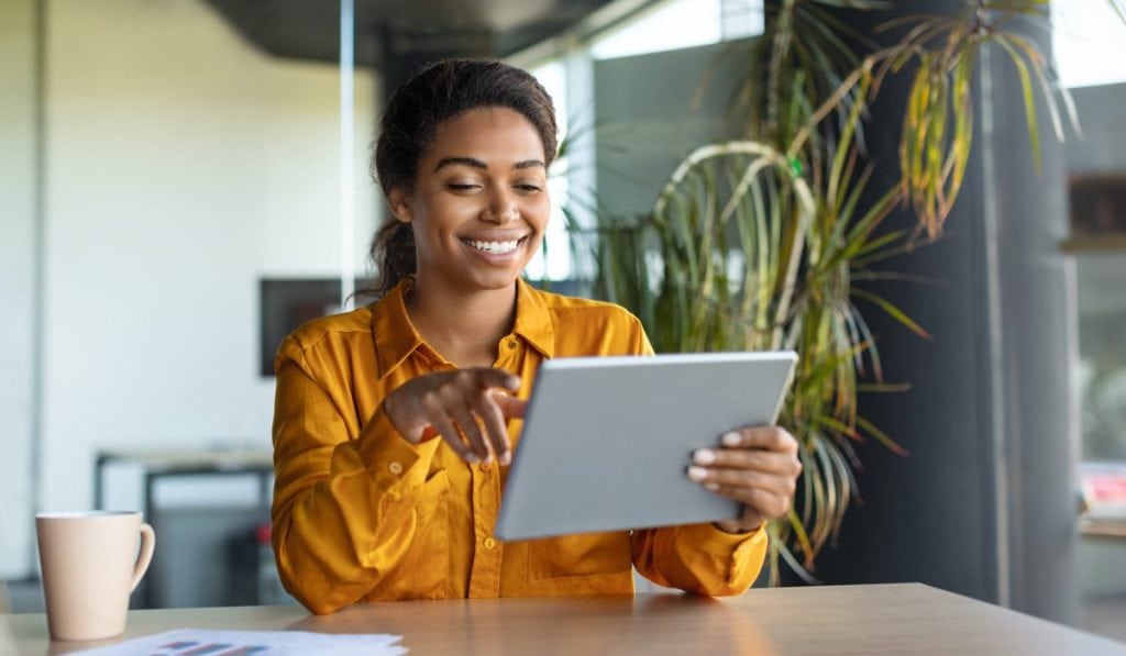 Woman using digital tablet for business or work at modern office Hozio Inc.
