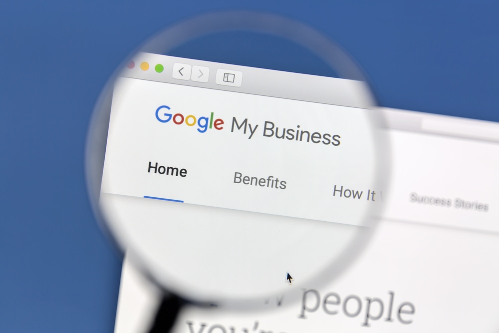 Google My Business page viewed through magnifying glass, representing online business listing management.