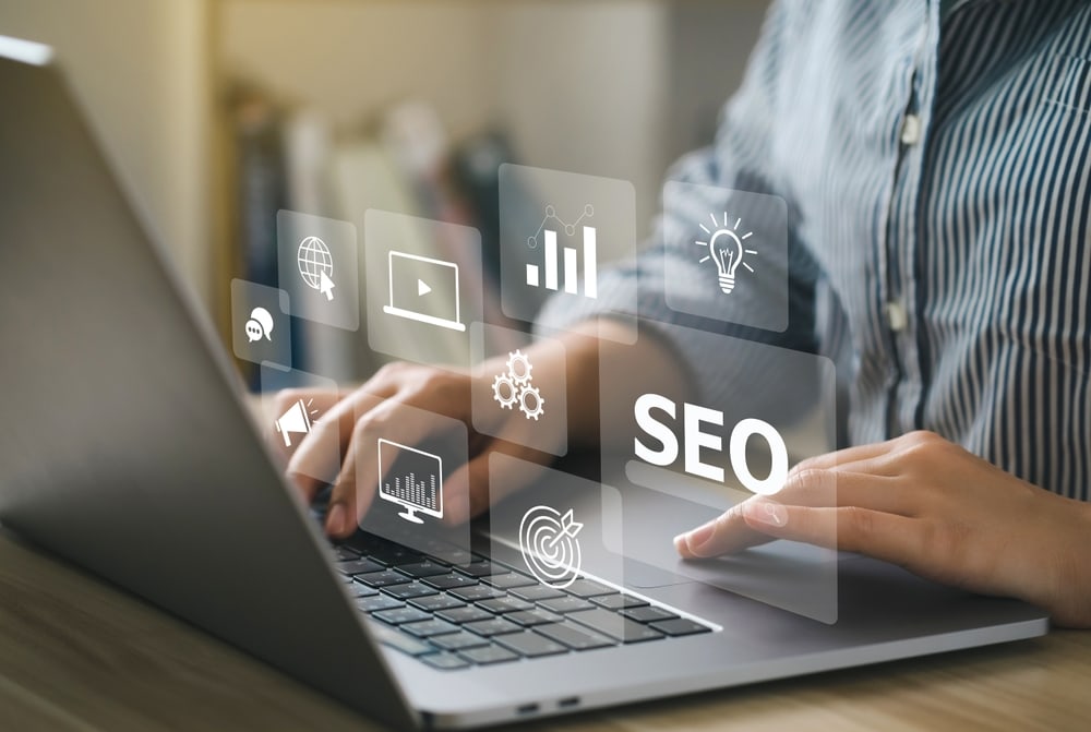 SEO optimization concept with digital icons and a person working on a laptop, representing SEO strategies and digital marketing.