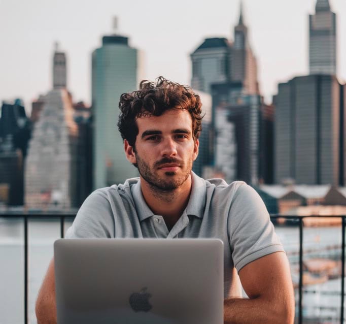 CoWorking space rental in urban skyline featuring a man working on a laptop.