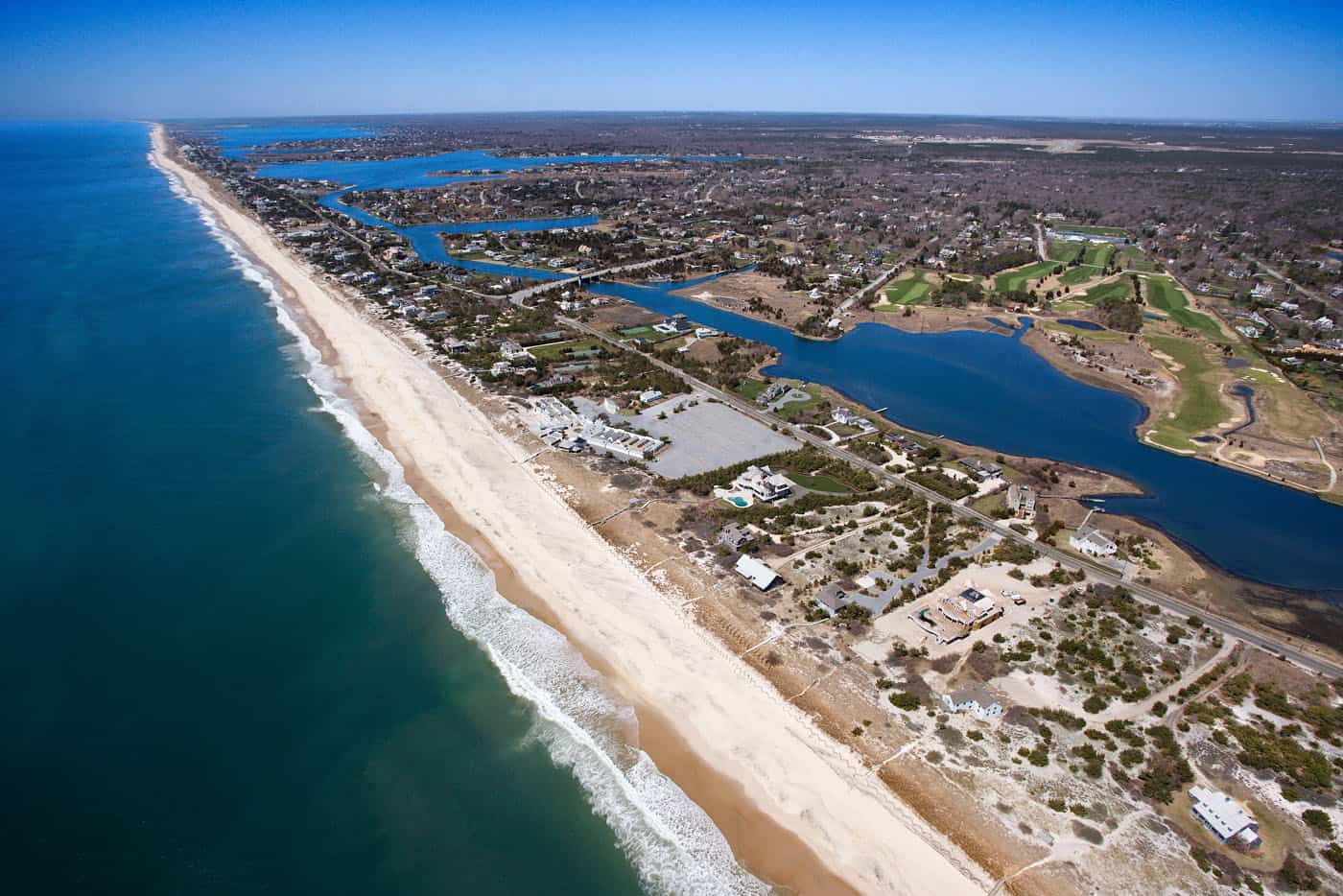 Seaside coastal landscape with beachfront homes and inland waterways.