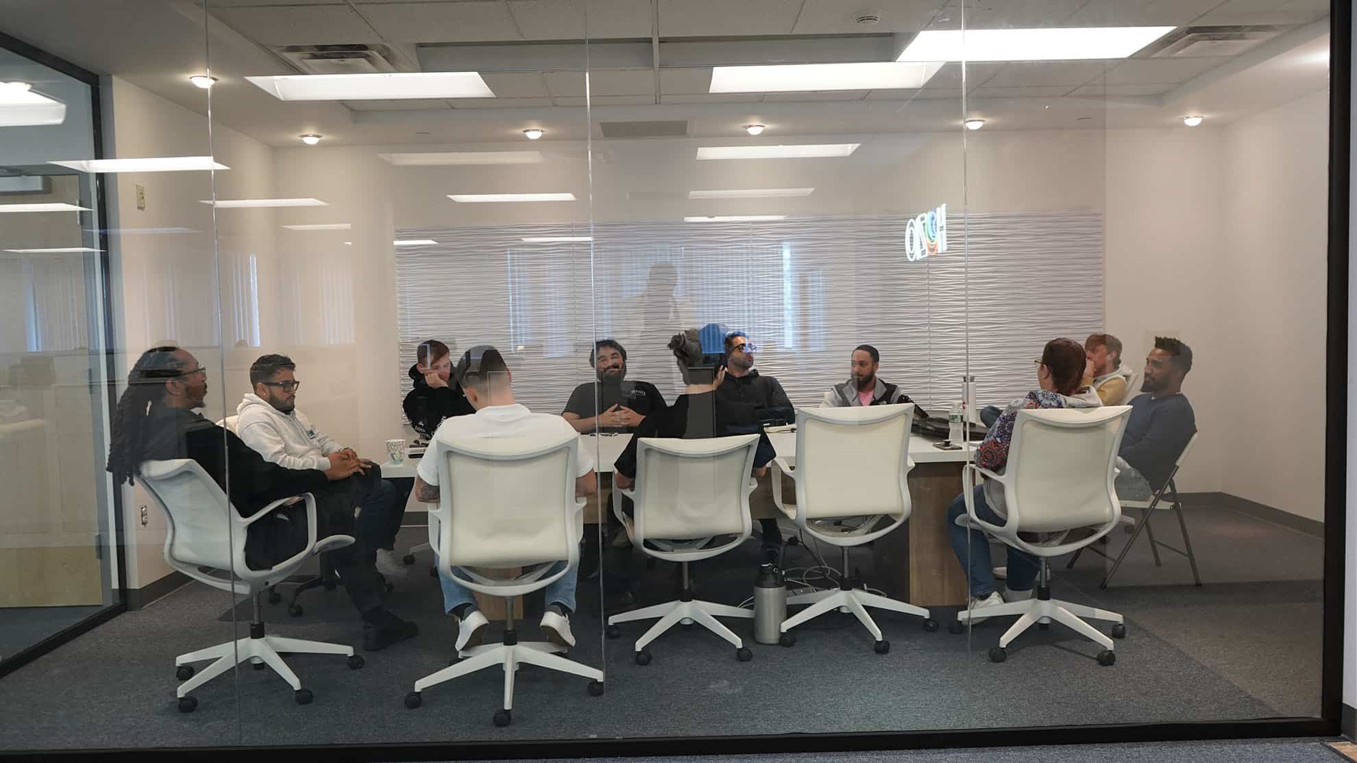 Modern diverse team participating in a virtual meeting in an office conference room.